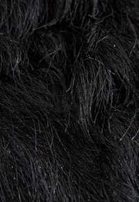 Pelo sintético negro con fibras largas y suaves que muestran una textura brillante. La superficie presenta un ligero brillo y longitudes de pelo variables.