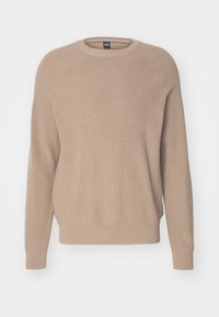 Beżowy sweter robiony na drutach z okrągłym dekoltem, długimi rękawami raglanowymi oraz ściągaczami przy rękawach i u dołu, prezentowany na białym tle.