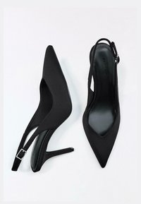 Pantofi cu toc înalt negri cu bareta la spate și vârf ascuțit, realizați din țesătură netedă. Au un toc subțire și o cataramă metalică pe baretă.