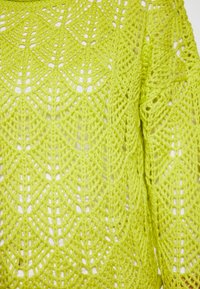 Spitzenstrick-Pullover in hellem Limettengrün. Verfügt über ein offenes Strickmuster mit geometrischen Designs und einem strukturierten, garnähnlichen Material.