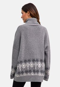 Maglione grigio lavorato a maglia con collo alto, caratterizzato da un motivo geometrico in grigio scuro e bianco sull'orlo e maniche testurizzate.