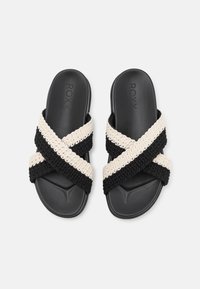 Sorte og kremfargede sandaler med kryssremmer, laget med et vevd tekstiloverdel og gummisåle, med et flatt design og behagelig passform.