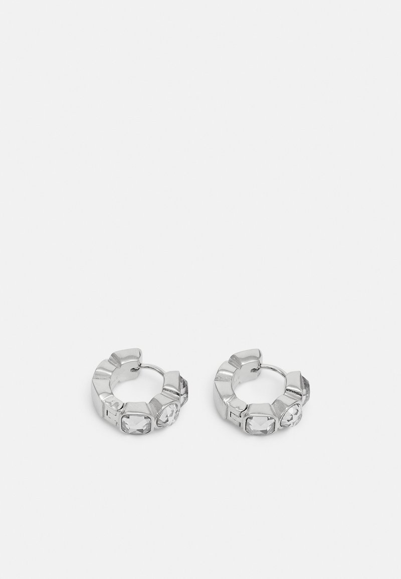 Paire de boucles d'oreilles créoles en argent avec des pierres précieuses rectangulaires transparentes disposées autour du bord extérieur sur un fond clair.