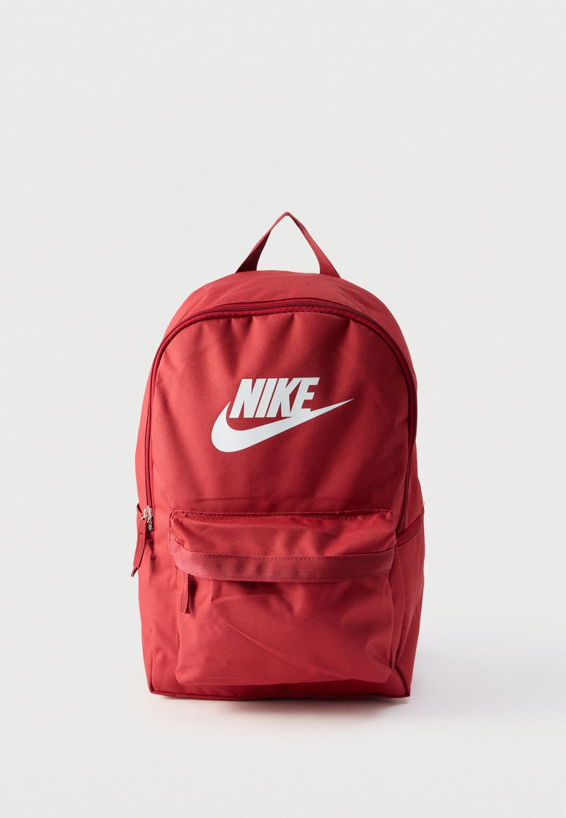 Zaino Nike rosso con logo bianco, tasca frontale con zip e manico superiore su sfondo bianco.