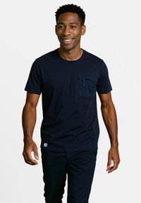 Navyblauw katoenen T-shirt met een ronde hals, korte mouwen en een ritszak op de linkerborst. Heeft een zachte textuur en een casual pasvorm.