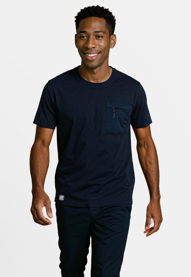 Navyblauw katoenen T-shirt met een ronde hals, korte mouwen en een ritszak op de linkerborst. Heeft een zachte textuur en een casual pasvorm.