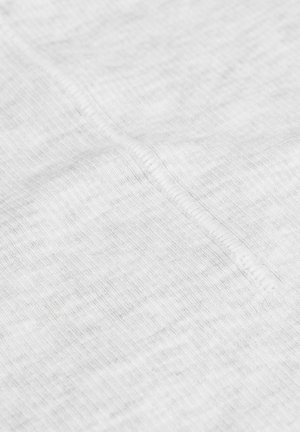 Vit bomullstyg med en texturerad yta. En synlig söm löper längs mitten, vilket visar jämna stygn och en mjuk framtoning.