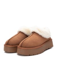 Zapatillas de ante marrón con un puño de felpa blanca. Suela gruesa y robusta con fondo texturizado. Detalles de costura simples en la parte superior.