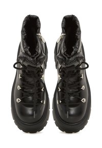 Botas de senderismo negras con un upper de cuero liso, collar acolchado, cordones negros, herrajes plateados y una suela de goma texturizada para mayor agarre.