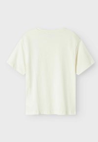 Camiseta de manga corta color crema claro con cuello redondo, textura suave y ajuste casual, que presenta bordes limpios y sin elementos de diseño visibles.