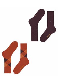 Deux paires de chaussettes : une couleur bordeaux avec une texture subtile et une marque, l'autre orange avec un motif argyle en orange, jaune et marron foncé.