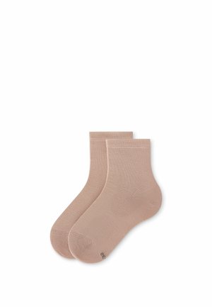 Paar schlichte beige knöchellange Socken, flach auf weißem Hintergrund liegend, wobei ein Socken den anderen leicht überlappt.