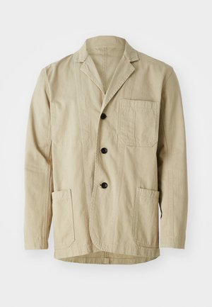 Beige cotton jacket with a notched collar, three buttons, three pockets, and a straight hem. Textured fabric with a minimalist design.