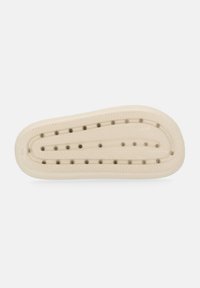 Insole in gomma beige con nodi massaggianti circolari rialzati disposti in due file per il comfort e il supporto del piede.