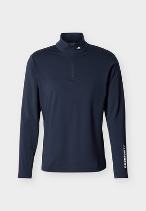 Tumesinise värvi pika varrukaga pullover neljandiku lukuga, kõrge kaelusega ja vasakul varrukal valge "J.LINDEBERG" tekstiga.