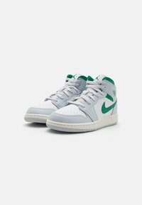Sneaker alte in pelle grigia chiara con accenti verdi, dotate di punta perforata, suola in gomma bianca e lacci. Design classico.