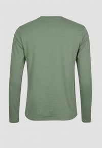 Camicia a maniche lunghe di colore verde chiaro, realizzata in tessuto morbido, con collo rotondo e vestibilità rilassata, dalla texture liscia e con cuciture minime.