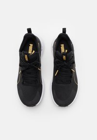 Schwarze Sportschuhe mit goldenen Akzenten, oberer Teil aus strukturiertem Mesh, gepolsterte Schaftränder und weiße Sohlen. Verfügt über ein Schnürsystem und ein Markenlogo auf der Zunge.