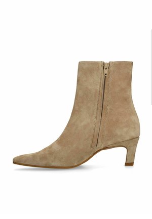 Beige suède enkellaars met spits toelopende neus, zijrits en lage kittenhak.