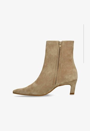 Beige suede ankle boot with pointed toe, side zipper, and low kitten heel.