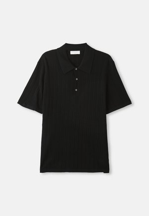 Camisola polo de manga curta preta em ribana com três botões e colarinho pontiagudo disposta sobre um fundo branco.