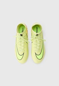 Scarpini da calcio di un brillante giallo neon con un design simile a una calza, caratterizzati da dettagli neri a forma di swoosh e tessuto leggermente testurizzato. I lacci sono visibili.