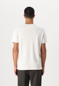 Gray short-sleeve t-shirt with a crew neck, made of light fabric, featuring a subtle texture and a V-shaped stitch design on the back.