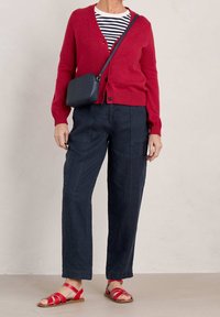 Red cardigan, navy striped shirt, dark cargo pants, and red strappy sandals. Complete with a small woven texture crossbody bag.