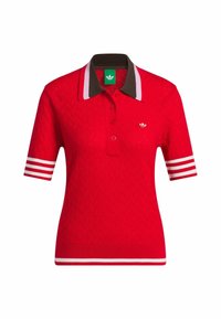Polo rouge en tricot à manches courtes, col marron, rayures blanches et violettes sur les manches et petit logo blanc sur la poitrine.