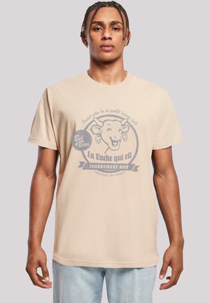 Beige cotton t-shirt featuring a graphic print of a smiling cow and text in grey. Short sleeves and a relaxed fit with a crew neckline.