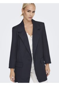 Blazer blu navy con vestibilità rilassata, ampi rever, maniche lunghe, tasche frontali e chiusura con un solo bottone. Tessuto dalla texture liscia.
