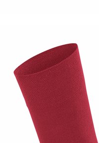 Rote Socke mit gerippter Textur, nahtlosem Design und weichem Finish. Der Bund ist elastisch für Komfort und Passform.