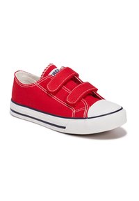 Zapatillas de lona rojas con dos correas de velcro, puntera de goma blanca y una franja azul a lo largo de la suela. Presentan detalles de costura blanca.