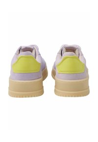 Sneakers with lavender suede upper and bright yellow accents on the heel. Beige rubber sole with horizontal grooves for traction.
