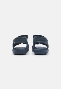 Sandalias azul marino con espalda abierta, correas ajustables, plantillas texturizadas y suelas de goma; fabricadas con materiales sintéticos para mayor durabilidad.