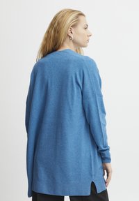 Langärmliger, hellblauer Pullover aus weichem Strickstoff mit lockerer Passform, seitlichen Schlitzen und abgerundetem Saum.