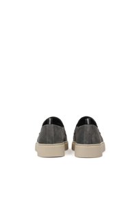 Zapatos de ante gris tipo slip-on con una suela de goma beige, que presentan una textura suave y acentos elásticos en la parte trasera para un fácil uso.
