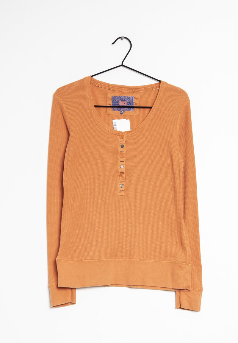 Haut à manches longues côtelé couleur orange brûlé, doté d'un décolleté rond et d'une patte à cinq boutons. Texture douce avec une coupe décontractée.