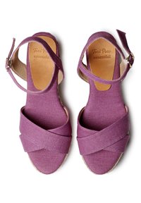 Sandali in tessuto viola con cinghie incrociate e fibbia alla caviglia. Tacco rivestito in juta e dettagli in morbido beige sulla soletta. Design con suola piatta.