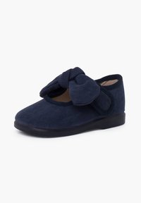 Scarpa in tessuto blu navy con punta rotonda e un grande fiocco decorativo sul davanti, dotata di un colletto imbottito e suola in gomma.