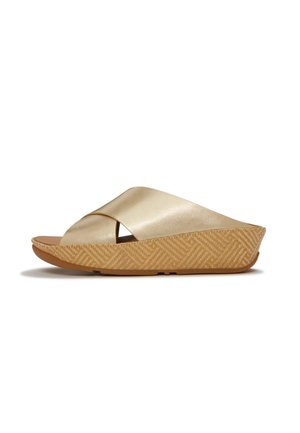 Beige sleehak sandaal met brede gekruiste banden en een textuurzool, ontworpen voor casual gebruik.