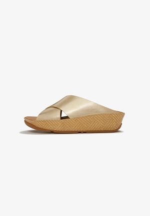Beige sleehak sandaal met brede gekruiste banden en een textuurzool, ontworpen voor casual gebruik.
