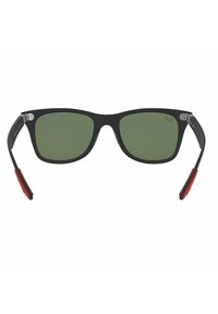 Occhiali da sole con montatura nera e lenti verdi. Le aste sono nere opache con dettagli in gomma rossa e hardware in argento. Forma rettangolare.