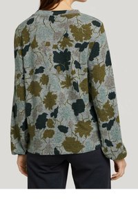 Fleece-paita, jossa on harmaa tausta ja tummanvihreitä sekä oliivinvihreitä kukkakuvioita. Pitkät hihat ja pyöreä pääntie täydentävät suunnittelua.