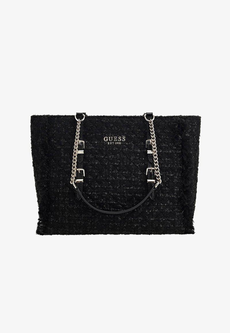 Sac à main Guess noir texturé avec chaîne argentée et poignées en cuir, avec le texte du logo "GUESS EST 1981" au centre avant.