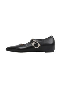 Zapato plano Mary Jane de cuero negro con puntera puntiaguda y gran hebilla plateada sobre fondo blanco.