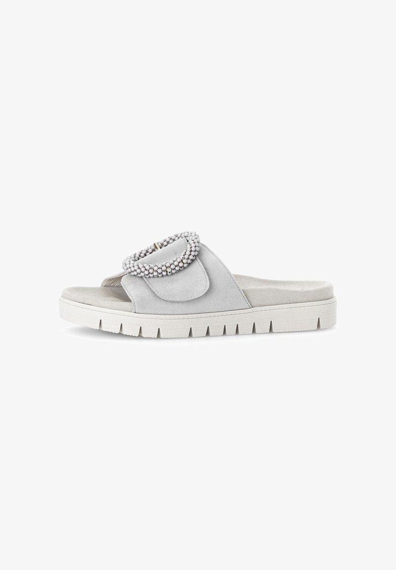 Gray suede slide sandals with a rounded, beaded accent on the strap and a textured white rubber sole. Flat design, casual style.