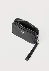 Μαύρο δερμάτινο clutch με φερμουάρ κλεισίματος, τρίγωνο λογότυπο και αποσπώμενο λουράκι καρπού. Λείος υφή με ασημένιες μεταλλικές λεπτομέρειες.