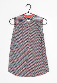 Ärmelloses Hemd mit geometrischem Muster in Rot, Blau und Weiß; Knopfleiste; Kragenhals; leichtes Gewebe; abgerundeter Saum.