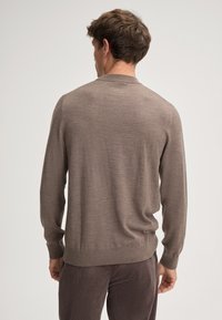 Brązowy sweter dzianinowy z długimi rękawami, ściągaczami przy mankietach i u dołu oraz okrągłym dekoltem. Miękka faktura i dopasowany krój.